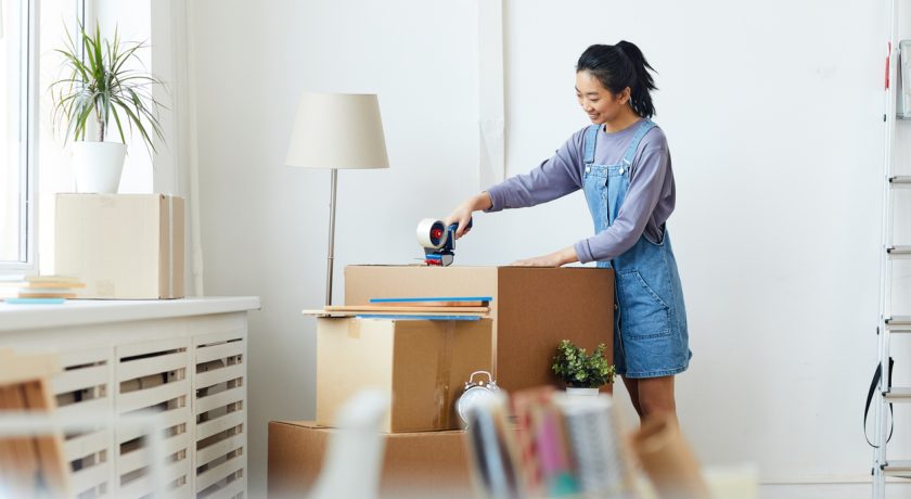 Woman packing belongings in boxes.