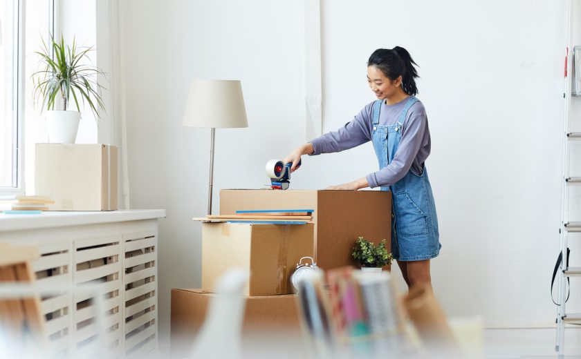 Woman packing belongings in boxes.
